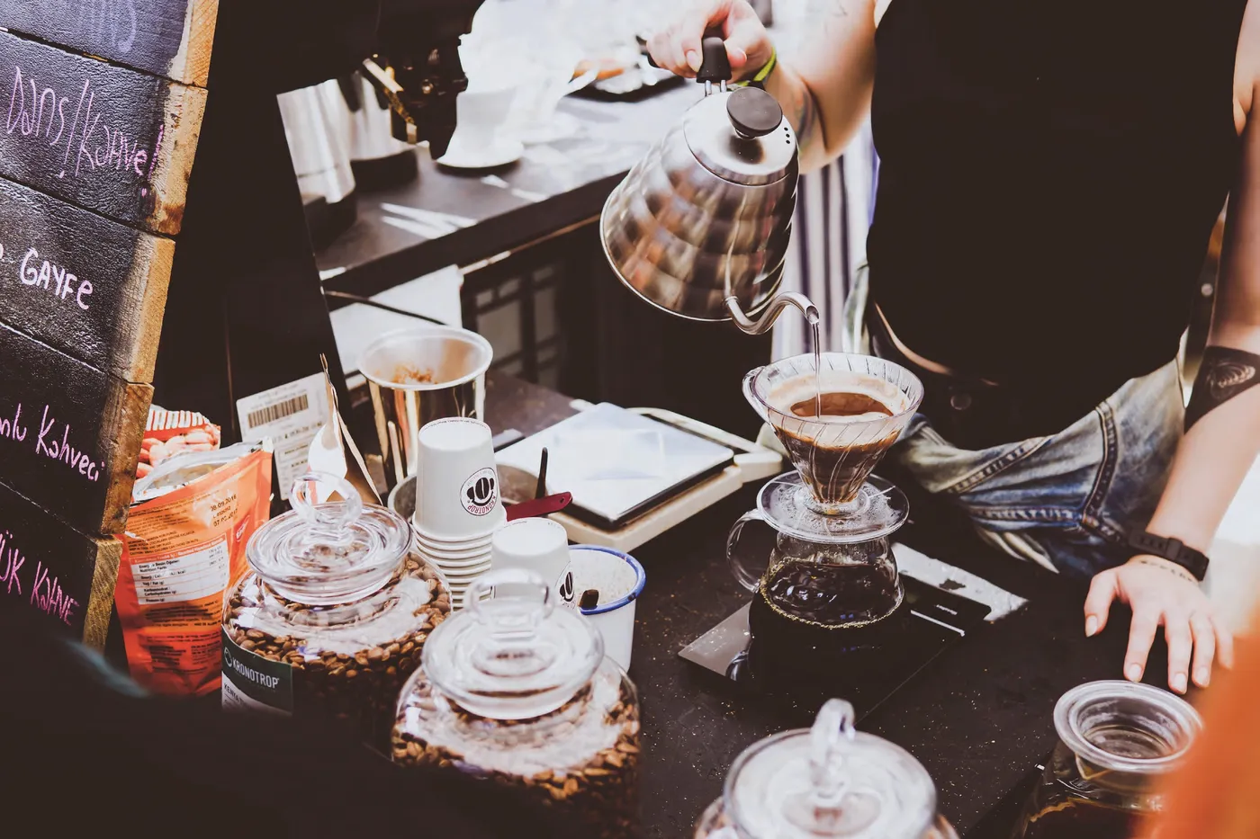 Coffee being brewed by hand at a café counter